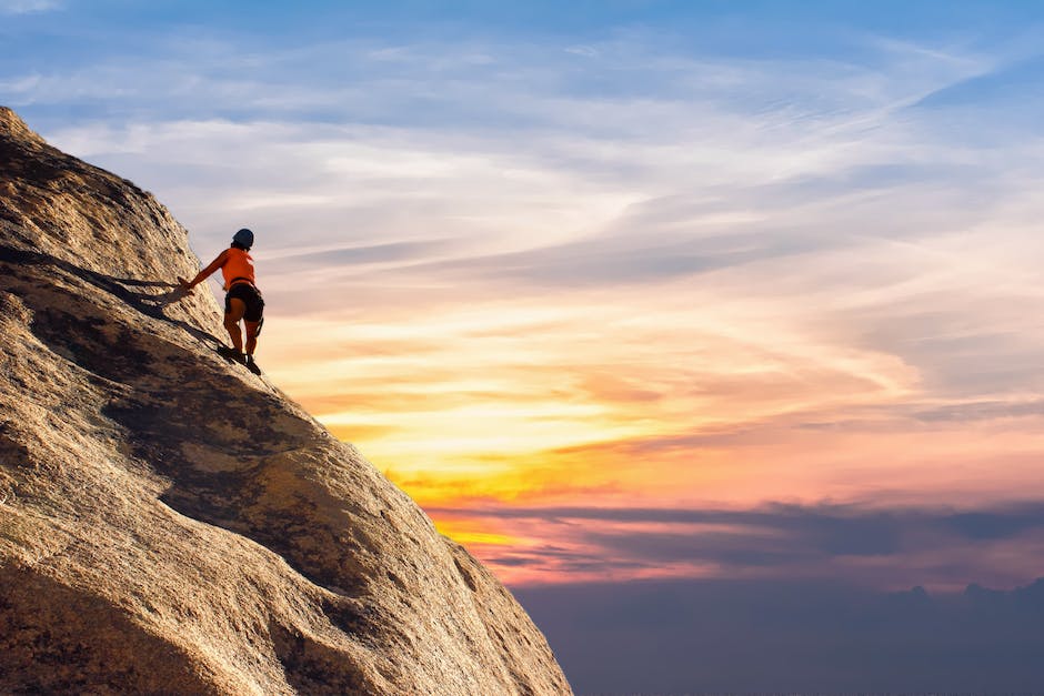 A person climbing a mountain, representing the concept of growth mindset and personal development.